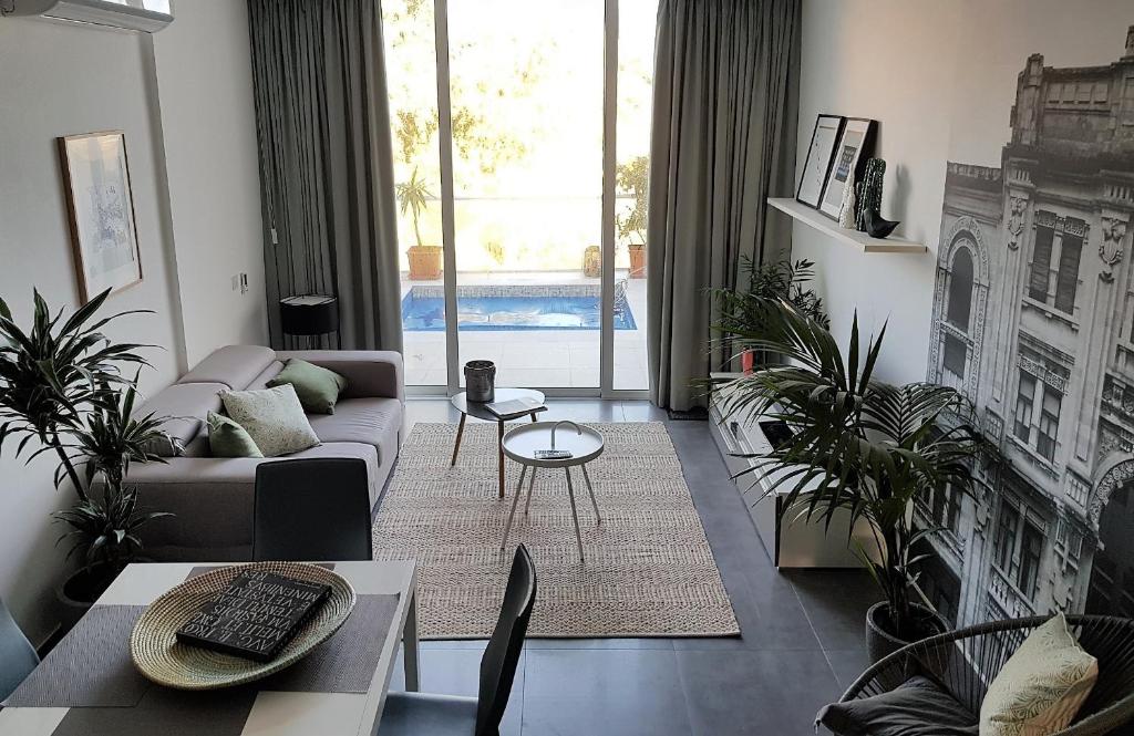 圣朱利安斯Duplex Maisonette with Heated P-Pool and Jacuzzi的带沙发和一些植物的客厅