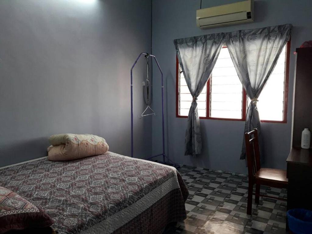 太平尤斯塔兹民宿的一间卧室设有一张床、一个窗口和一把椅子