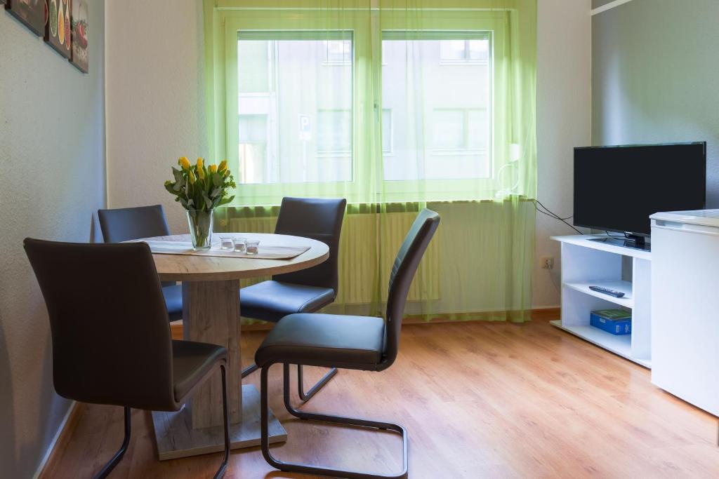 维滕Apartment Wideystrasse的一间带桌椅和电视的用餐室