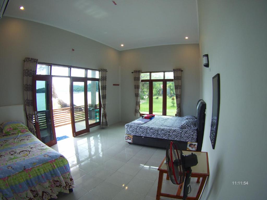 沙璜全景塞拉库住宿加早餐旅馆的一间卧室设有两张床和两个窗户。
