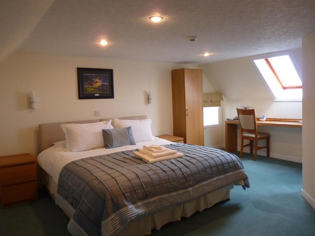 瑟索Pentland Lodge House的一间卧室配有一张床和一张桌子及椅子