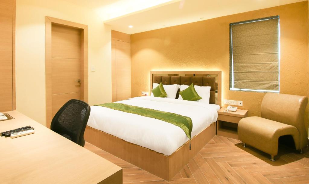 加尔各答Treebo Trend Hoops - Airport的配有一张床和一张书桌的酒店客房