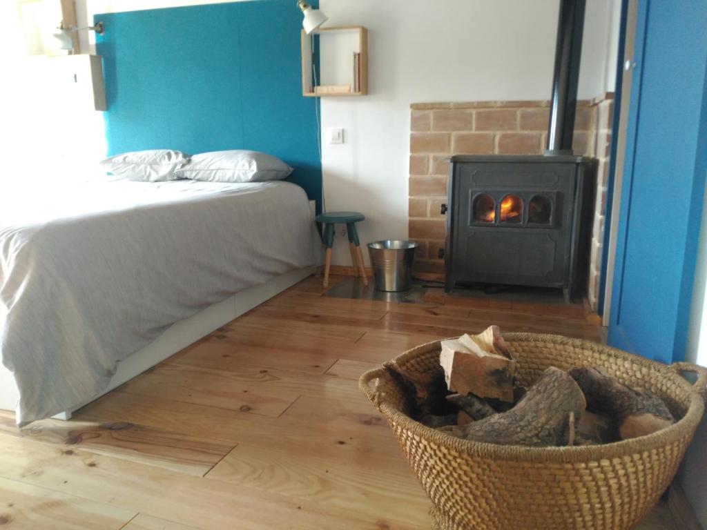 昆卡El Pretil del Olmo的一间卧室配有一张床和一个带壁炉的篮子