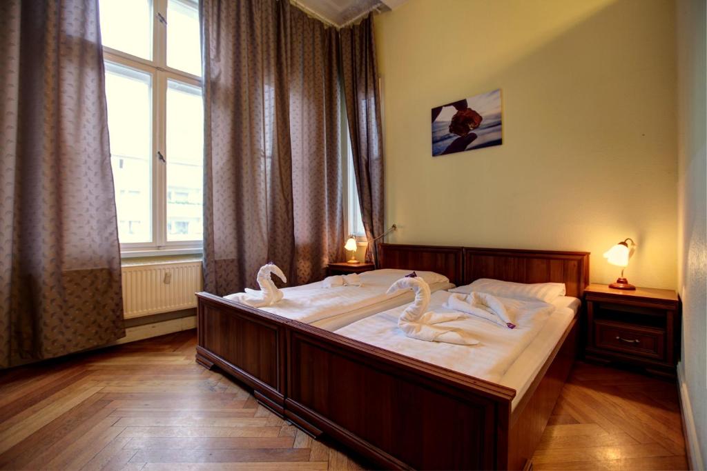 柏林选帝侯大街伯恩斯汀潘森酒店的一间卧室配有一张大床,上面有天鹅