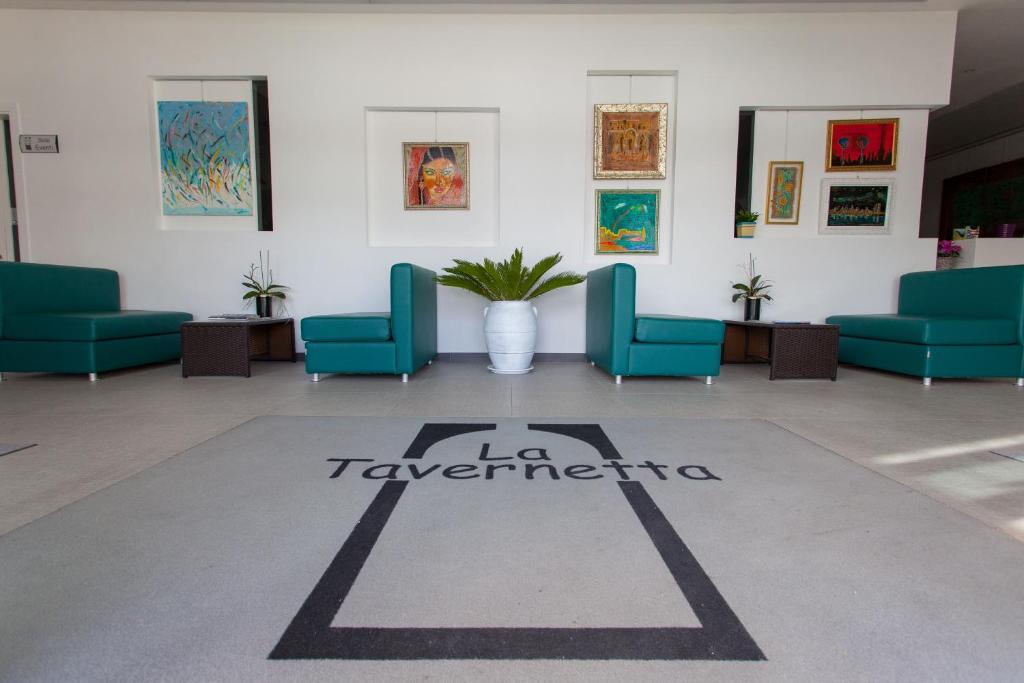 坎波巴索拉泰沃纳塔酒店的一间位于地板上的带蓝色椅子和标志的等候室