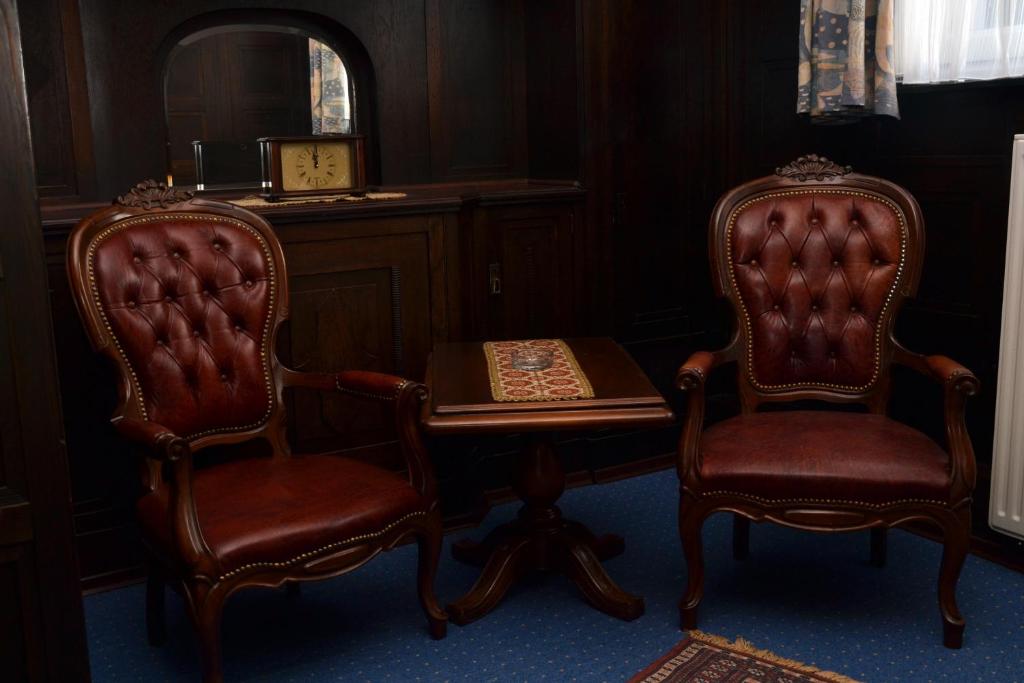 不来梅港安德尔卡尔施塔特酒店的配有书桌的客房内配有两把椅子和一张桌子