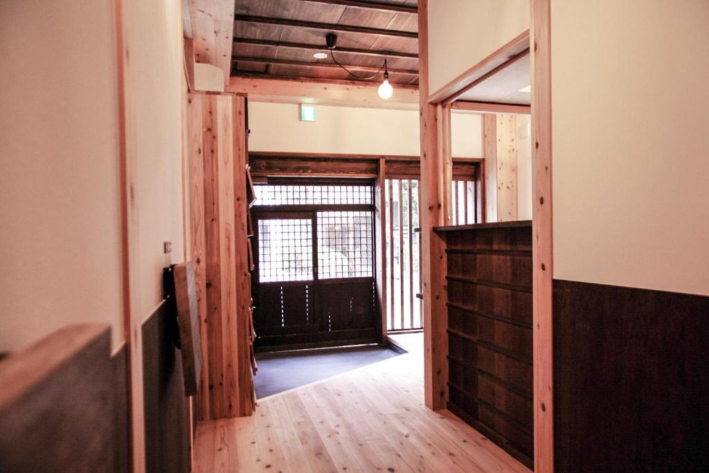 大阪难波波哩2号旅舍的走廊设有门,通往铺有木地板的客房