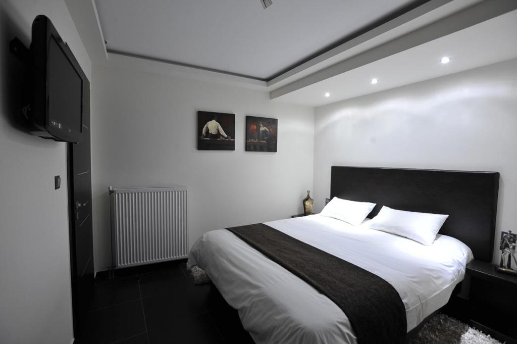 约阿尼纳迪卢索之家酒店的一间卧室配有一张床和一台平面电视