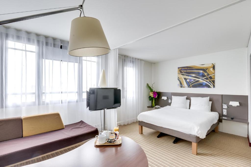 巴黎巴黎蒙特勒伊文森斯诺富特套房酒店的酒店客房,配有床和沙发