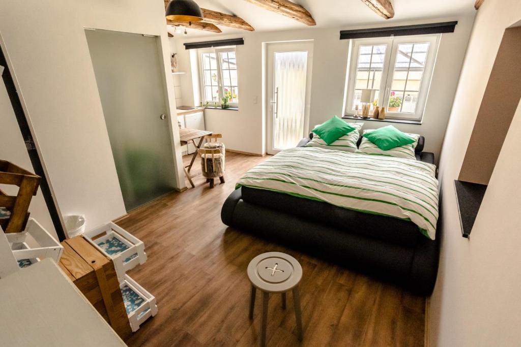 吕德斯海姆Fewo " Schmiede " Innenstadt, ruhige Lage, große Terrasse, Wlan inkl.的一间卧室配有一张带绿色枕头的床