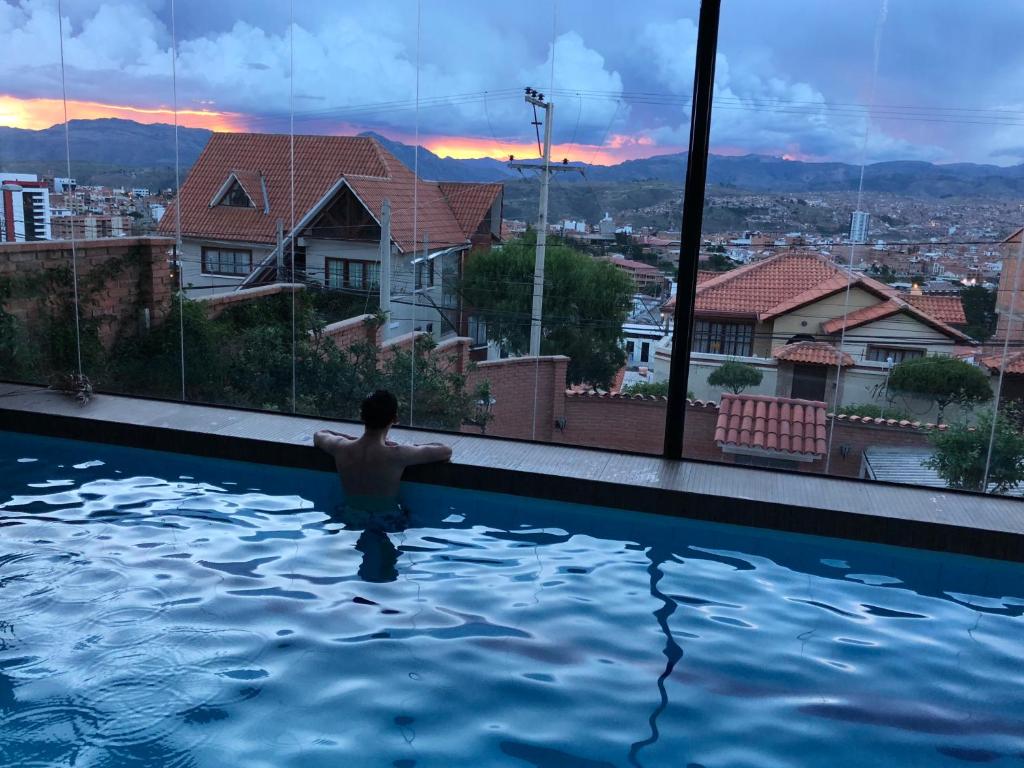 苏克雷Apartment with beautiful landscape的城市景游泳池中的男人