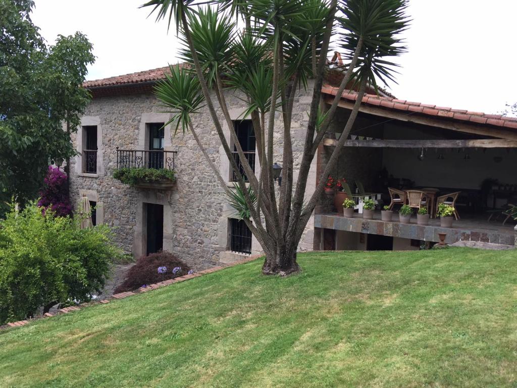比利亚维西奥萨Casa De Vacaciones La Rivera的前面有棕榈树的房子