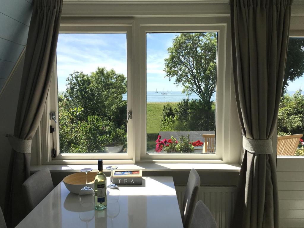 斯塔福伦Slapen aan het IJsselmeer的客房设有桌子和享有美景的窗户。