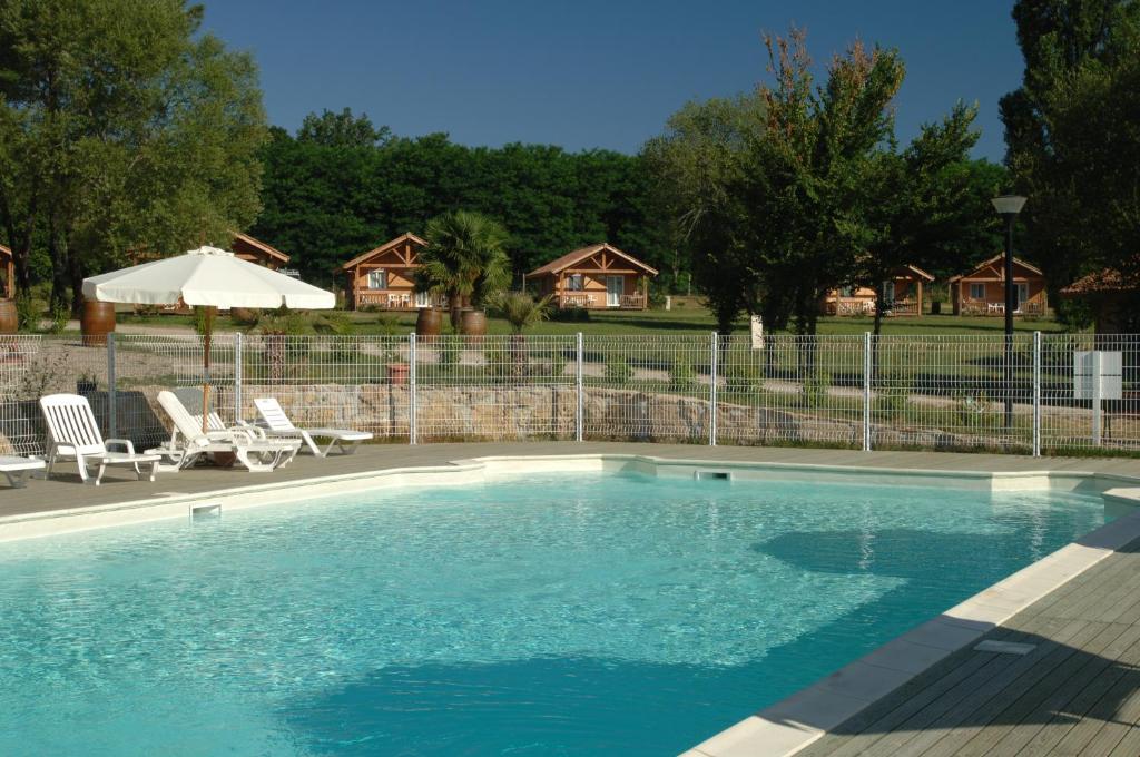 维兰德拉奥特罗伊凯斯玛庄园酒店的一个带两把椅子和遮阳伞的游泳池