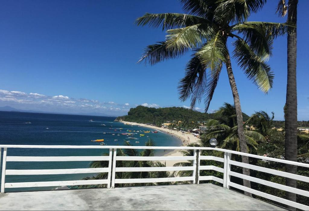 波尔多·格尼拉Playa Blanca Beach Resort的享有海滩美景,设有白色的围栏和棕榈树