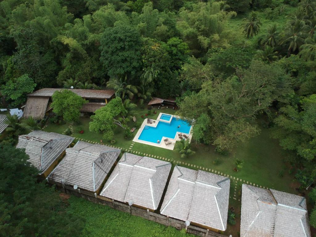 科隆大自然度假酒店的享有带游泳池和树木的度假屋的顶部景致