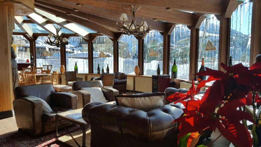 塞斯特雷Grand Hotel Sestriere的带沙发和桌子的客厅以及窗户。