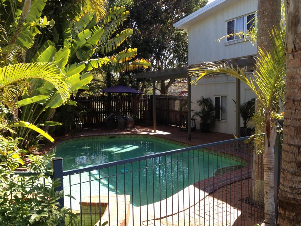 赫维湾海湾椰树酒店的一座房子旁带围栏的游泳池