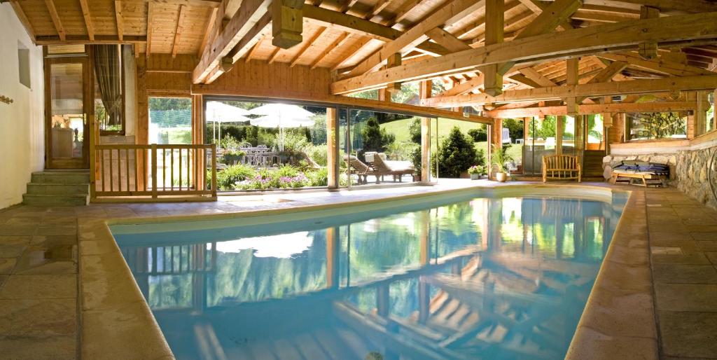 夏蒙尼-勃朗峰棕榈游戏酒店的一座带木制天花板的房屋内的室内游泳池