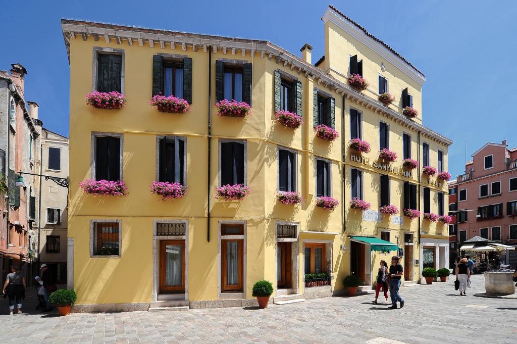 威尼斯圣塔马丽娜酒店的一座黄色的建筑,里面装有花盒