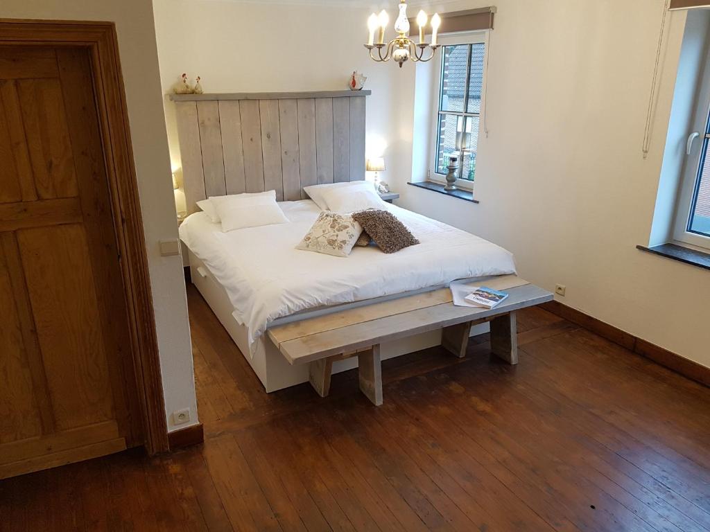 韦伦Widdingenhof的卧室配有白色的床,铺有木地板