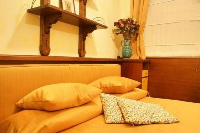 布拉格汀斯卡公寓式酒店的一张带两个枕头的床和墙上的花瓶