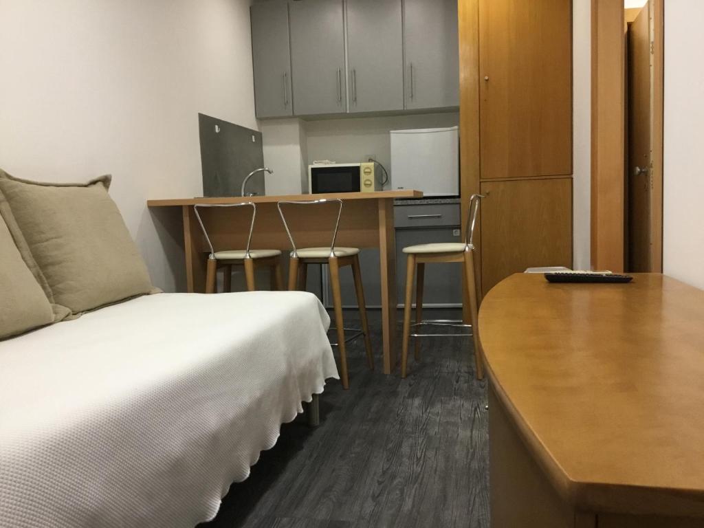 波尔图斯库洛公寓的客房设有一张床、一张书桌和一间厨房