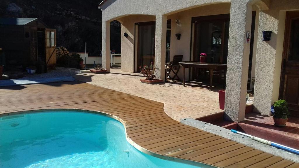 科利尤尔Les hauteurs de Collioure的一座带木甲板的游泳池,位于一座房子旁边