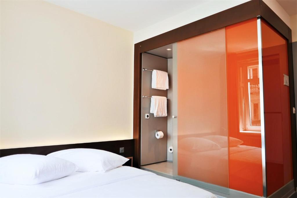 苏黎世easyHotel Zürich City Centre的卧室设有通往床的大型玻璃门