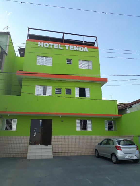 瓜鲁柳斯Hotel tenda 1的绿色建筑,上面有酒店塔马拉标志