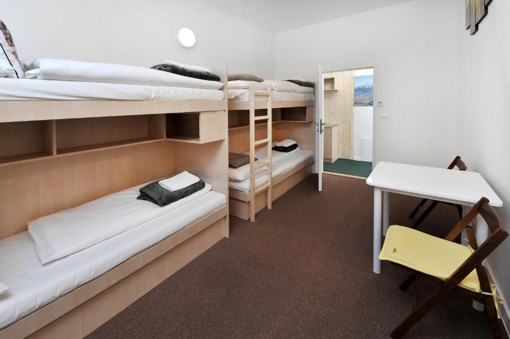 塔查斯卡-鲁穆尼卡Bel Hostel的客房设有双层床、书桌和桌子。