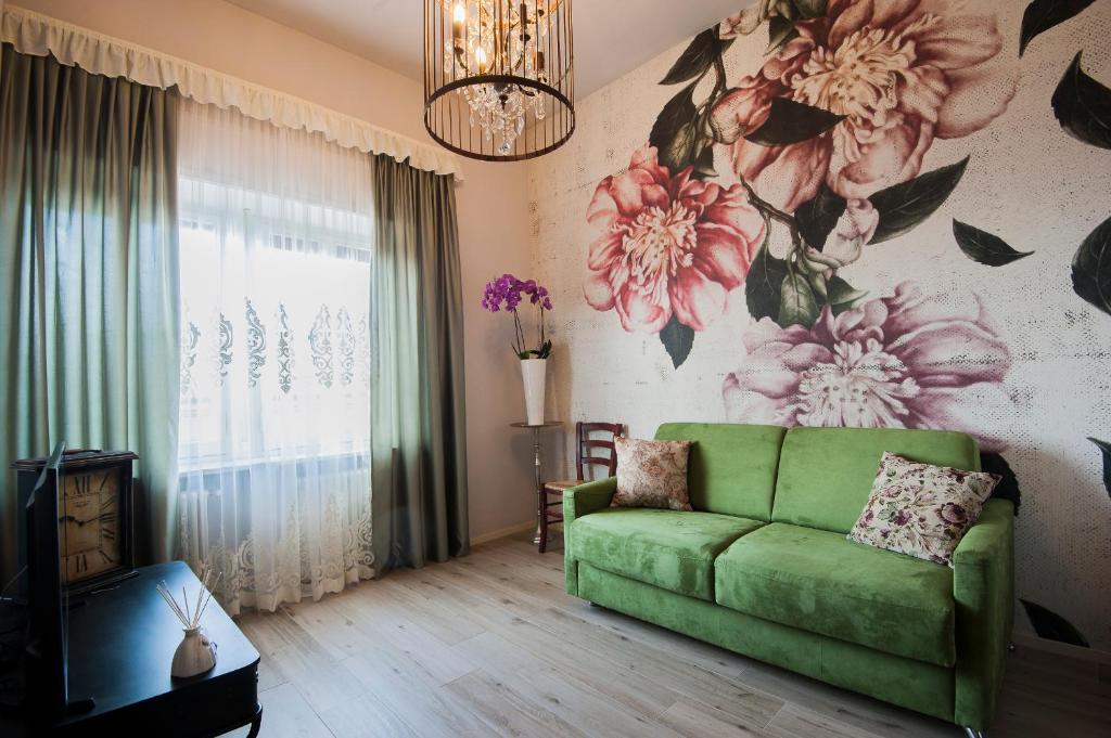 圣马力诺Locanda Jole Alloggio的客厅配有绿色沙发和花卉壁画
