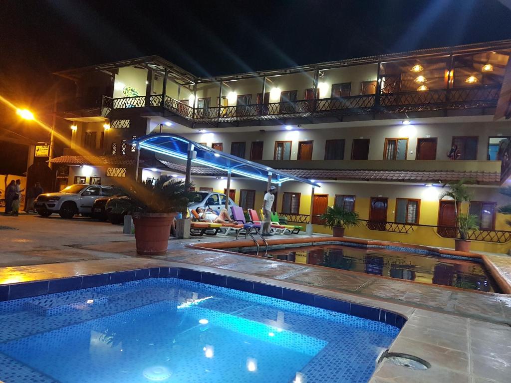 卡诺阿Hotel Mediterraneo的夜间在酒店前的游泳池