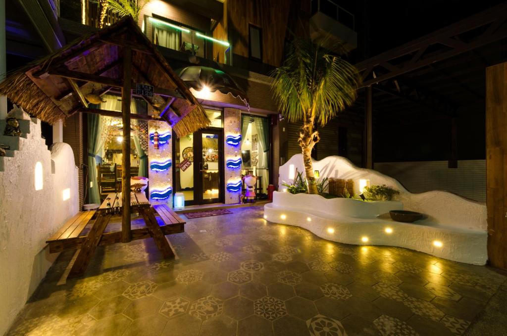 恒春古城夏湾旅店的一座棕榈树和灯光照在地板上的建筑