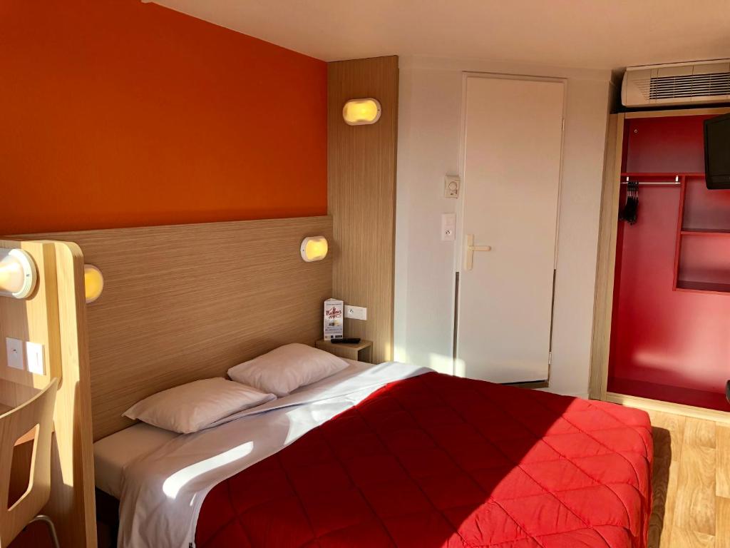 佩皮尼昂南佩尼皮昂普瑞米尔经典酒店的一间卧室配有一张带红色毯子的床