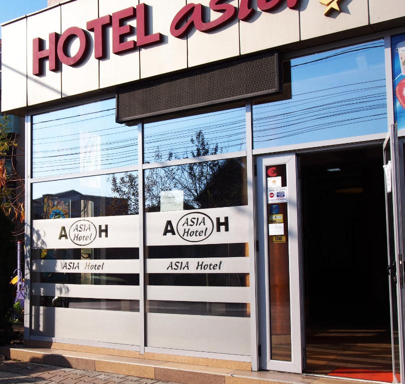 塔古玖Asia Hotel的大楼一侧的酒店出口标志