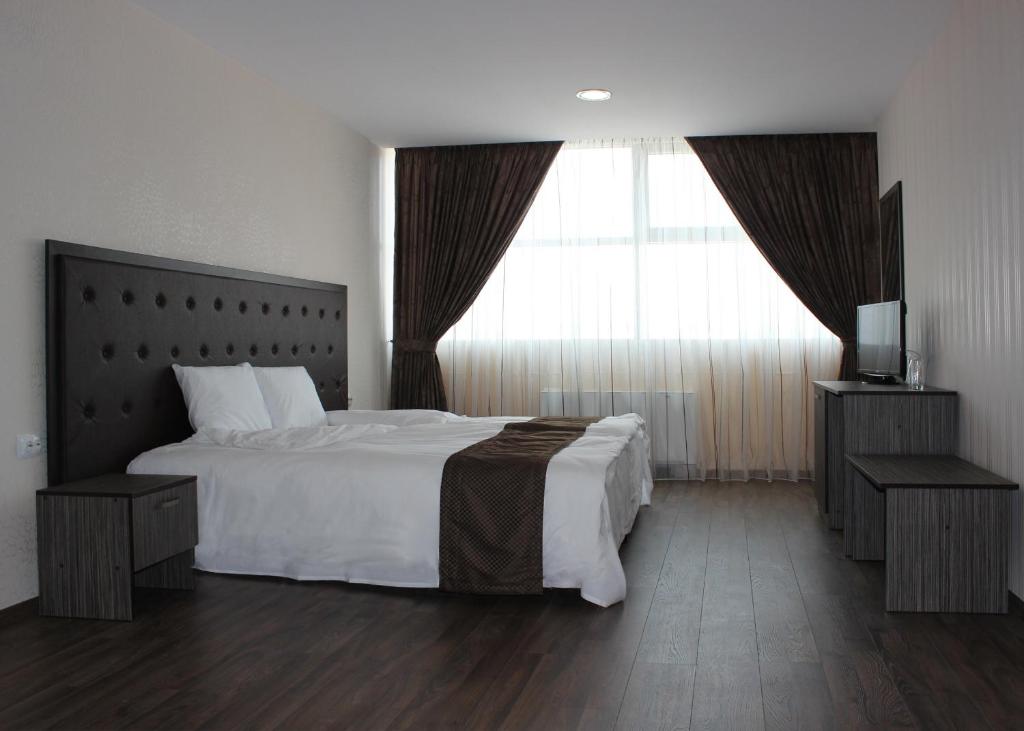 SilistraFamily Hotel Silistra的卧室设有一张白色大床和一扇窗户。