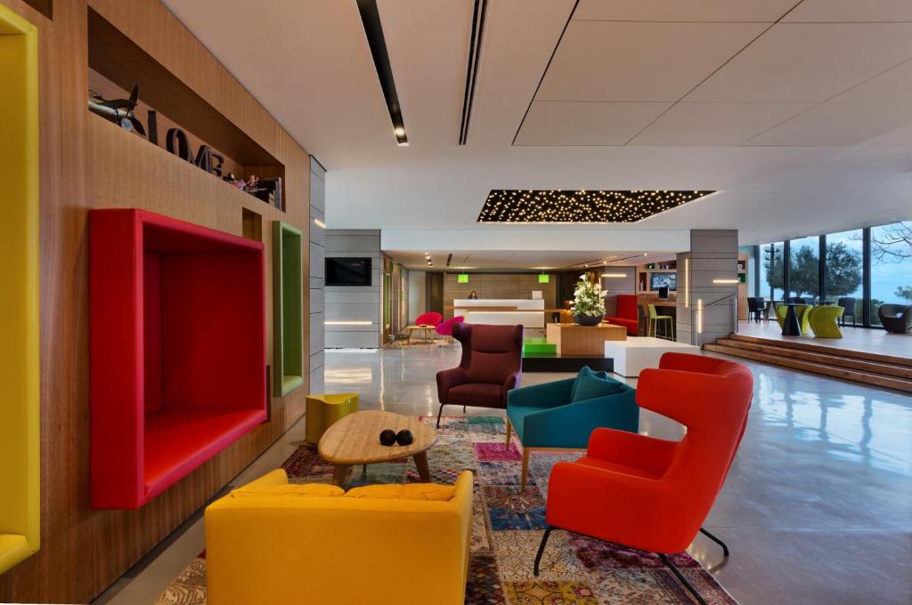 海法Haifa Bay View Hotel By AFI Hotels的大堂设有色彩缤纷的椅子和客厅