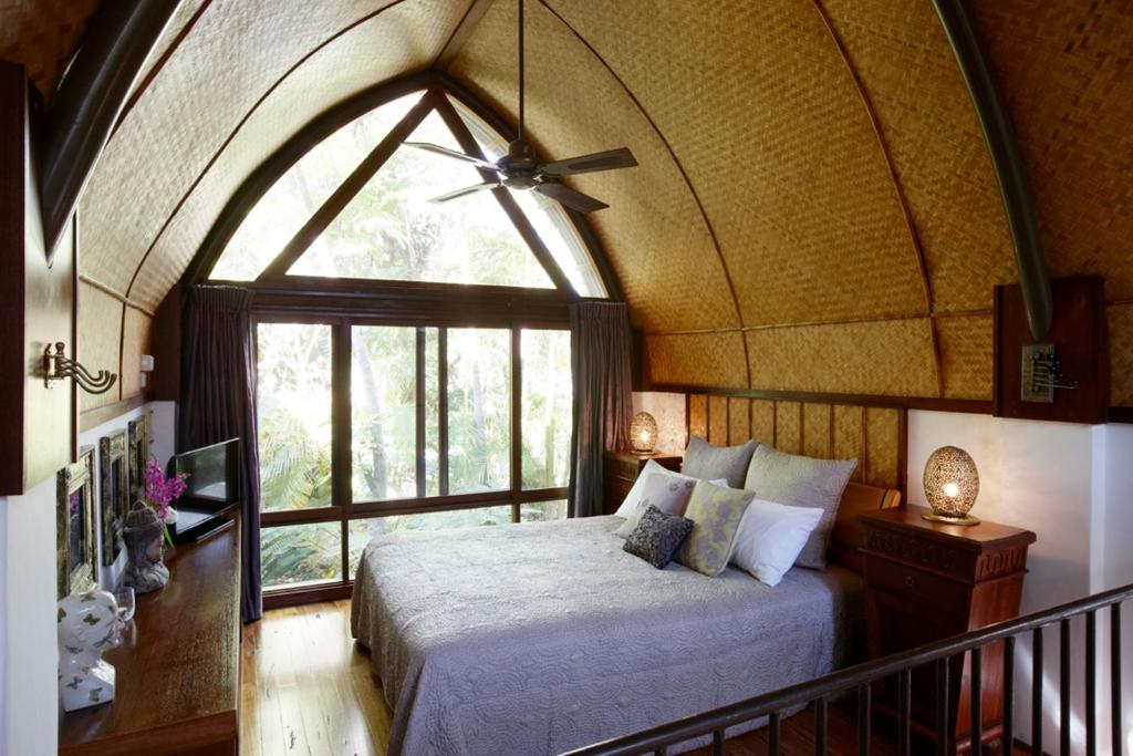 拜伦湾布里斯花园酒店的一间卧室设有一张床和一个大窗户