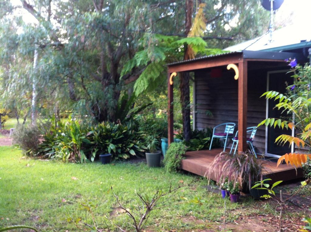 楠立镇中心旅馆的小屋设有门廊和庭院内的椅子