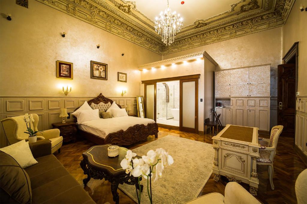 克拉约瓦Hotel 5 Continents的一间卧室配有一张床、一张沙发和一张桌子