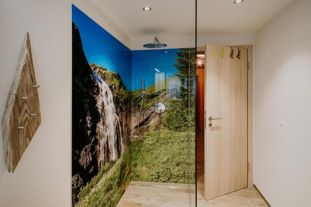 阿德尔博登阿洛亚木屋的浴室的墙上挂有瀑布画