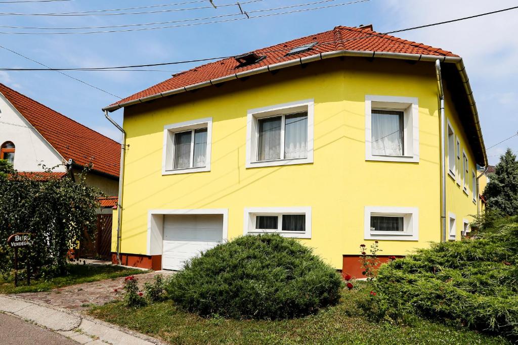 埃格尔Burg Vendégház的黄色的房屋,有红色的屋顶
