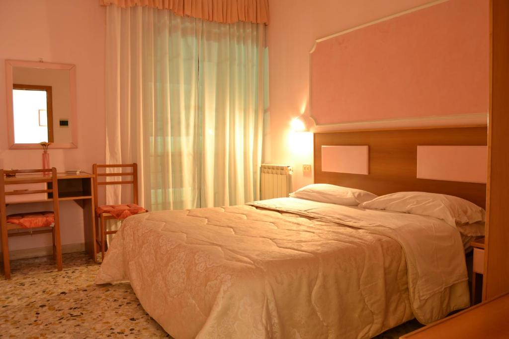 索伦托琳达酒店的一间卧室设有一张大床和一个窗户。