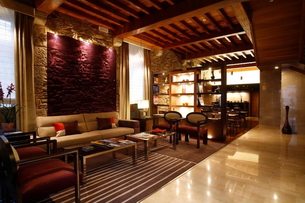 圣地亚哥－德孔波斯特拉阿尔塔酒店的客厅配有沙发和桌子