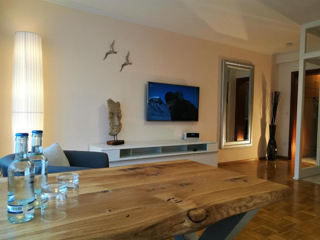 巴特皮尔蒙特Bonsai-Apartment III An der Hufeland Therme的客厅配有木桌和电视。