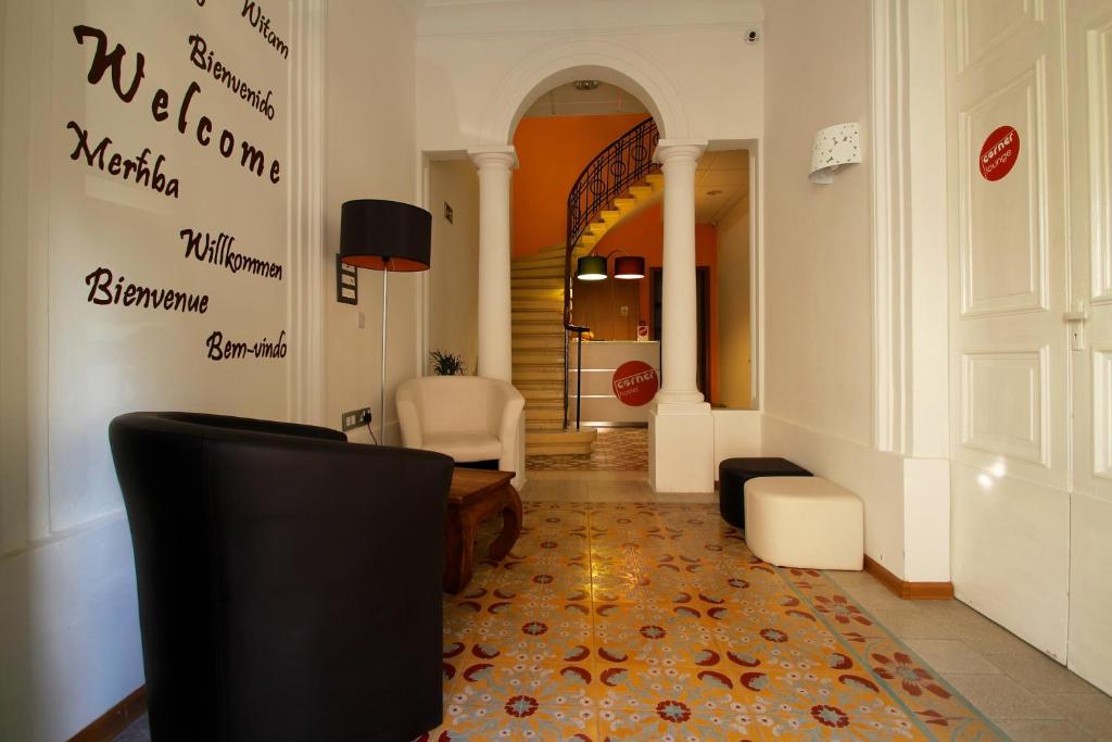 斯利马考奈尔旅馆的走廊上设有带沙发和椅子的客厅