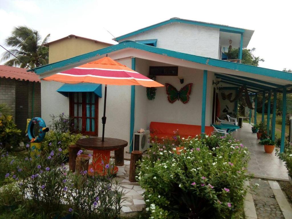 圣安德烈斯Blue Ocean Village的花园里的房屋,配有桌子和遮阳伞