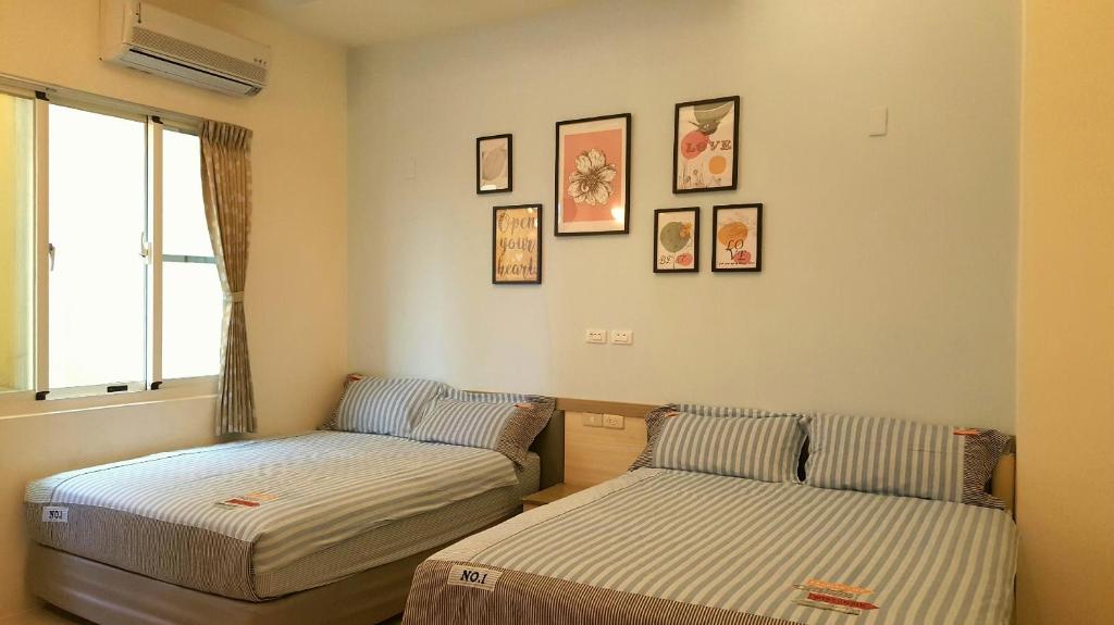 绿岛绿岛海猪宅 的一间设有两张床的客房,墙上挂有图片