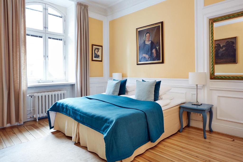 斯德哥尔摩霍格斯坦酒店 的一间卧室配有一张带蓝色毯子的床